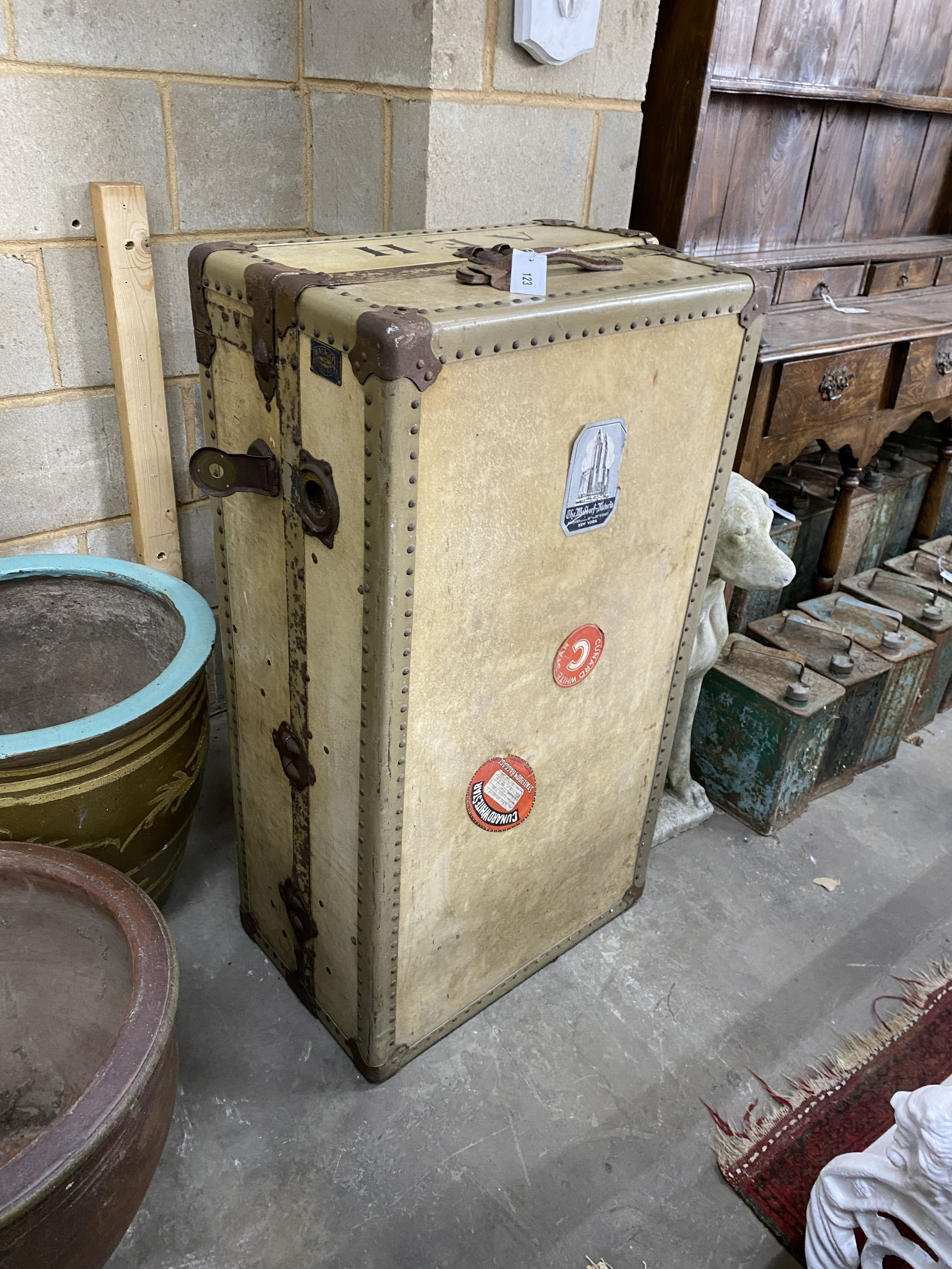 An early 20th century vellum 'Watajoy' compactum trunk, once the property of Ashley Havinden, bears Queen Mary voyage label, width 104cm